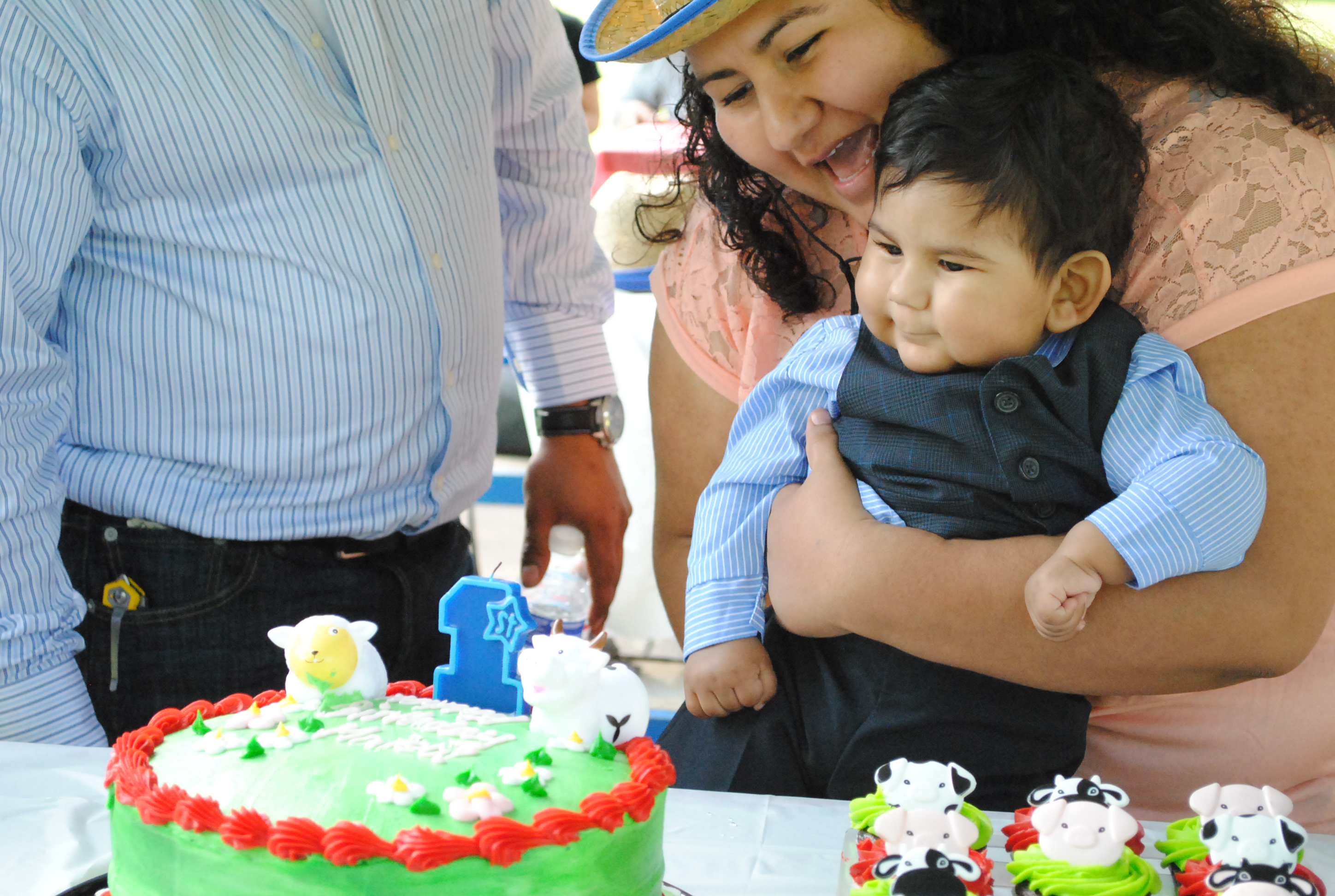 Mateo and his parents with a cake on his first birthday