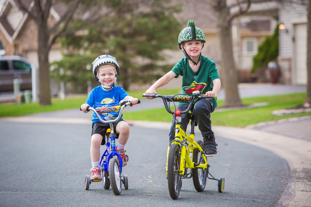 Two boys ride their bikes.