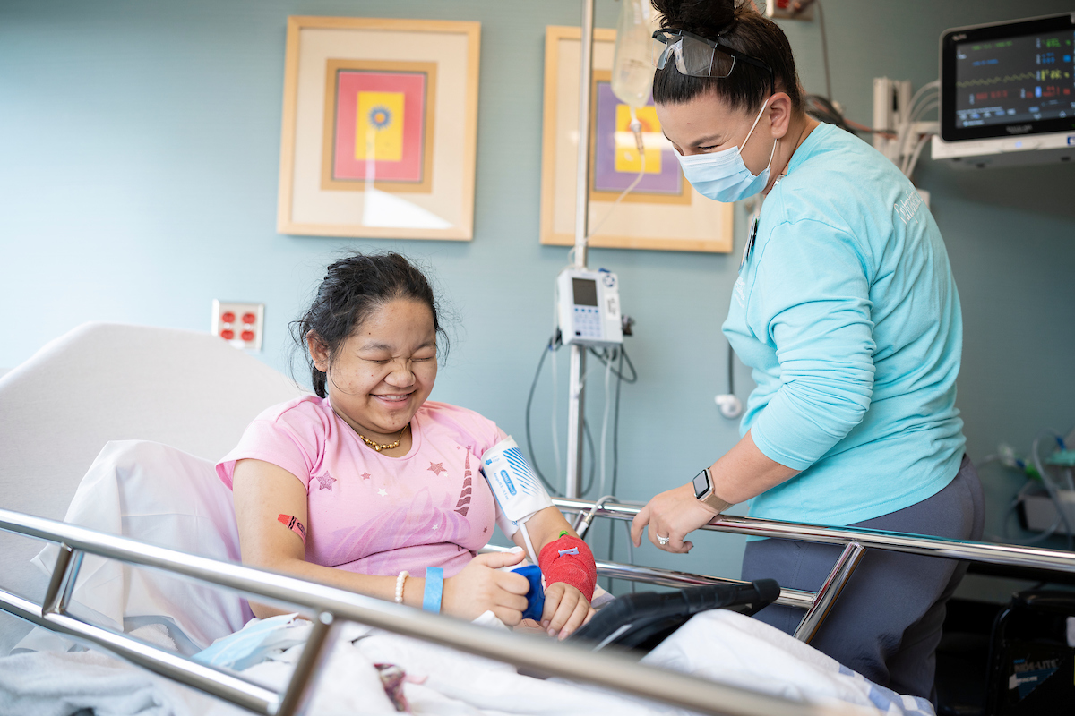 A Gillette patient laughs with her nurse.