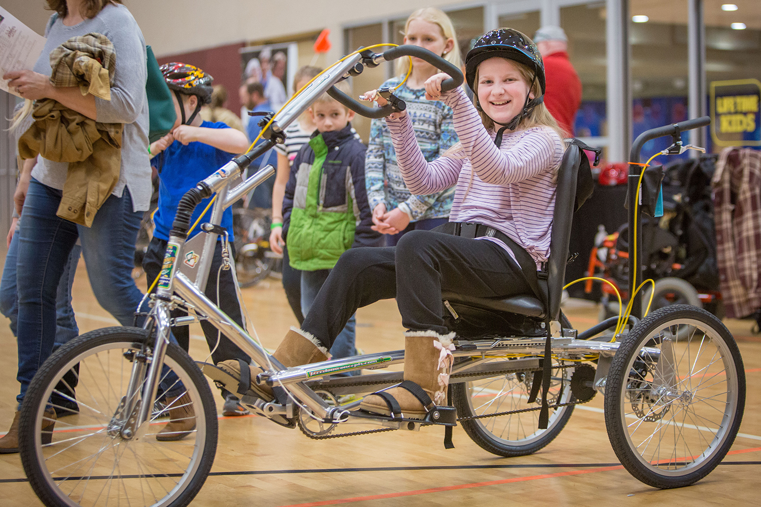 Kiara tries her first adapted bike at the expo.