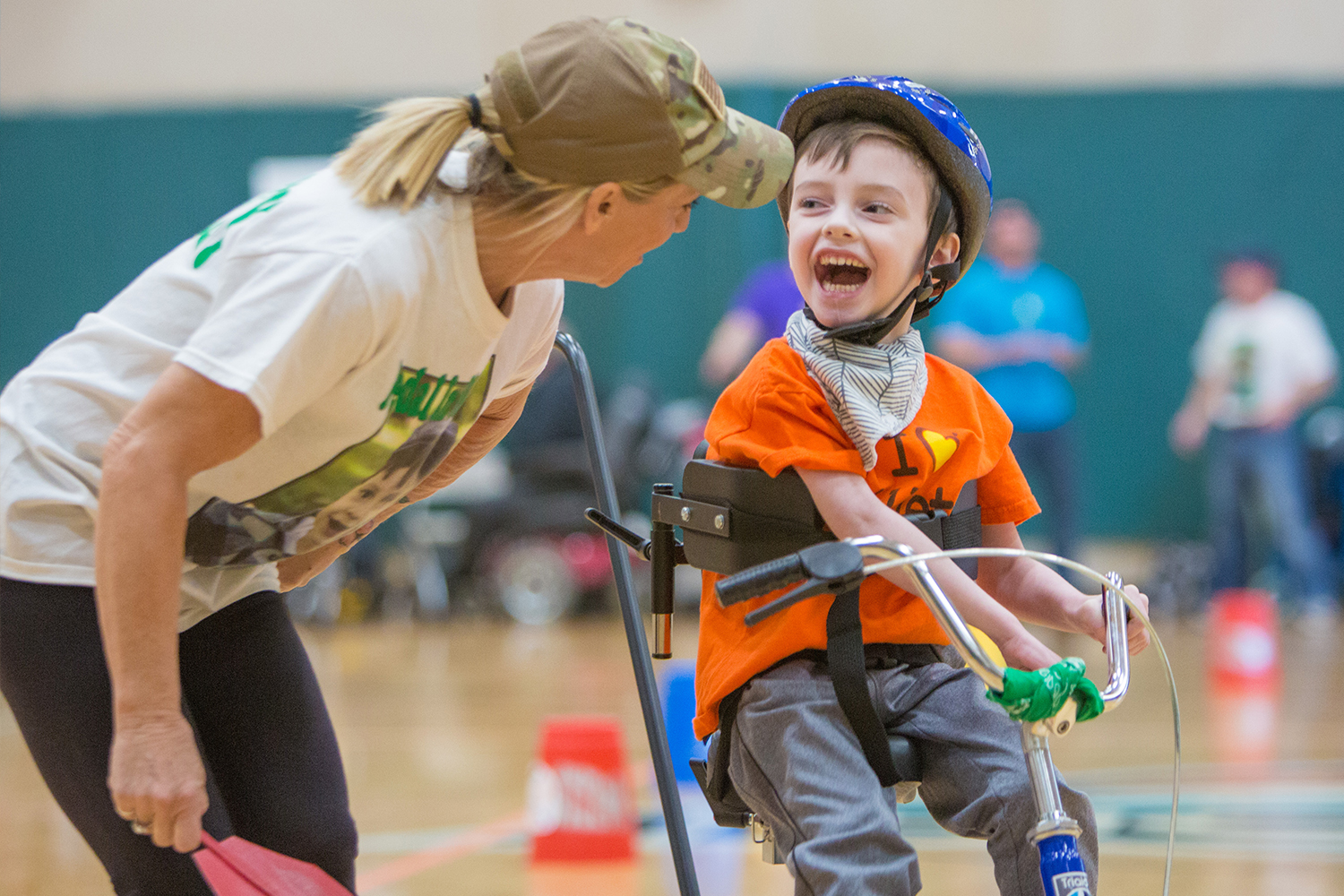A boy smiles as he tries an adapted bike at the expo.