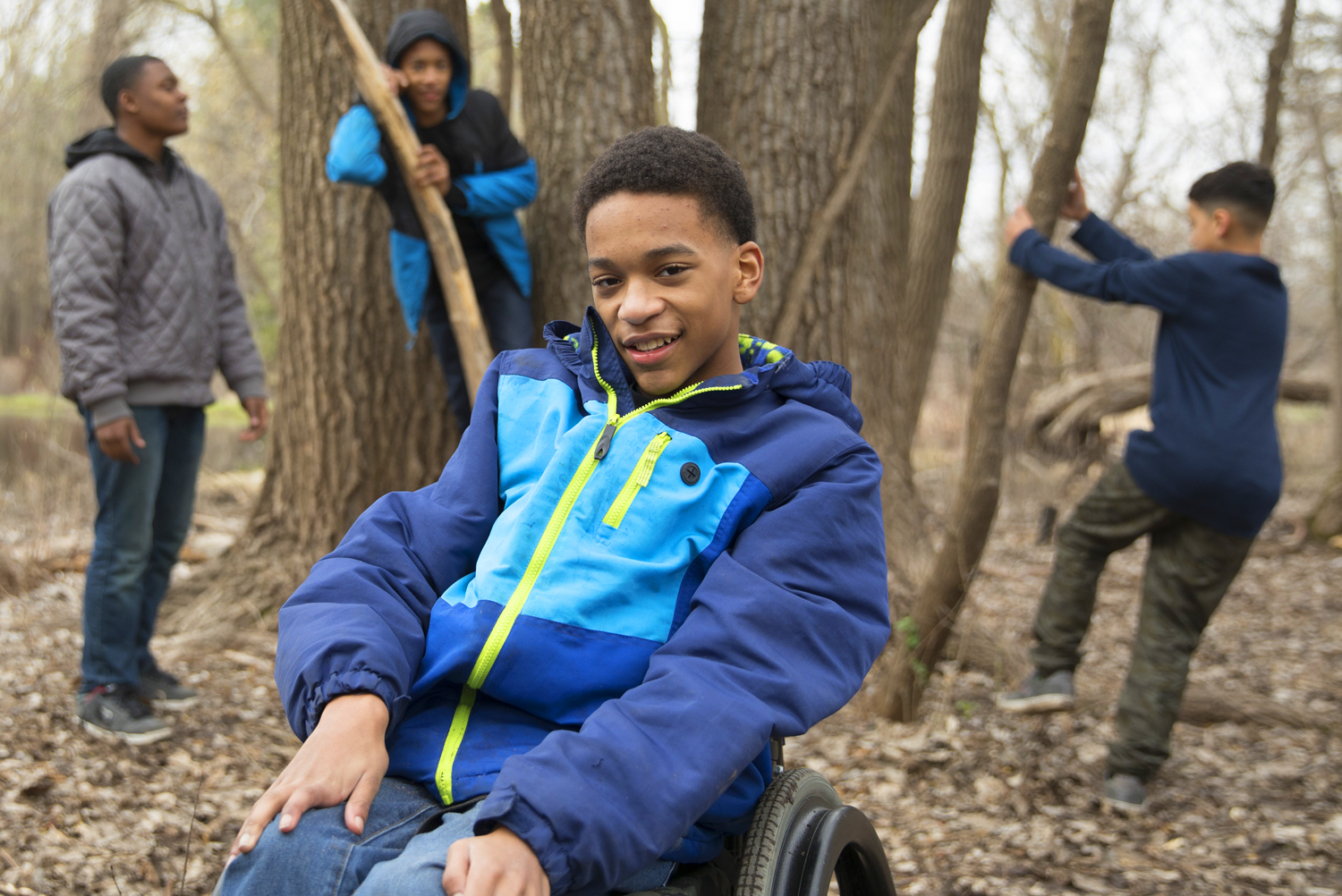 Elijah, who has cerebral palsy, enjoys playing in the woods with his buddies.