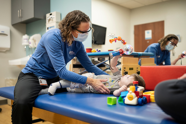 Physical therapist playing with little boy