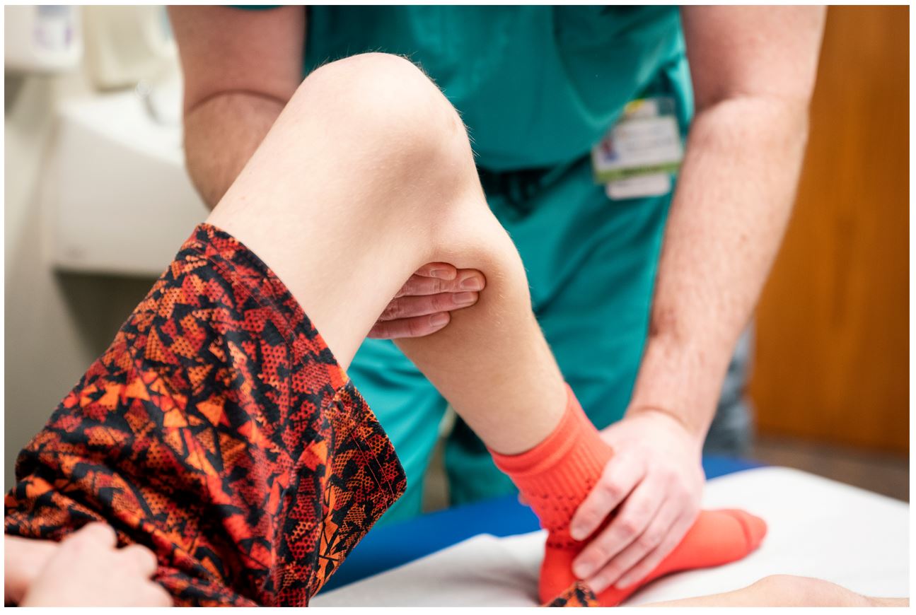 Gillette Pediatric Orthopedic Surgeon Trenton Cooper DO, MS checking a patient's knee