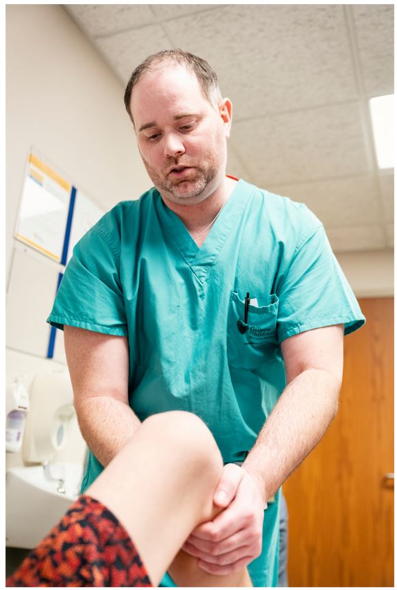 Gillette Pediatric Orthopedic Surgeon Trenton Cooper DO, MS checking a patient's knee