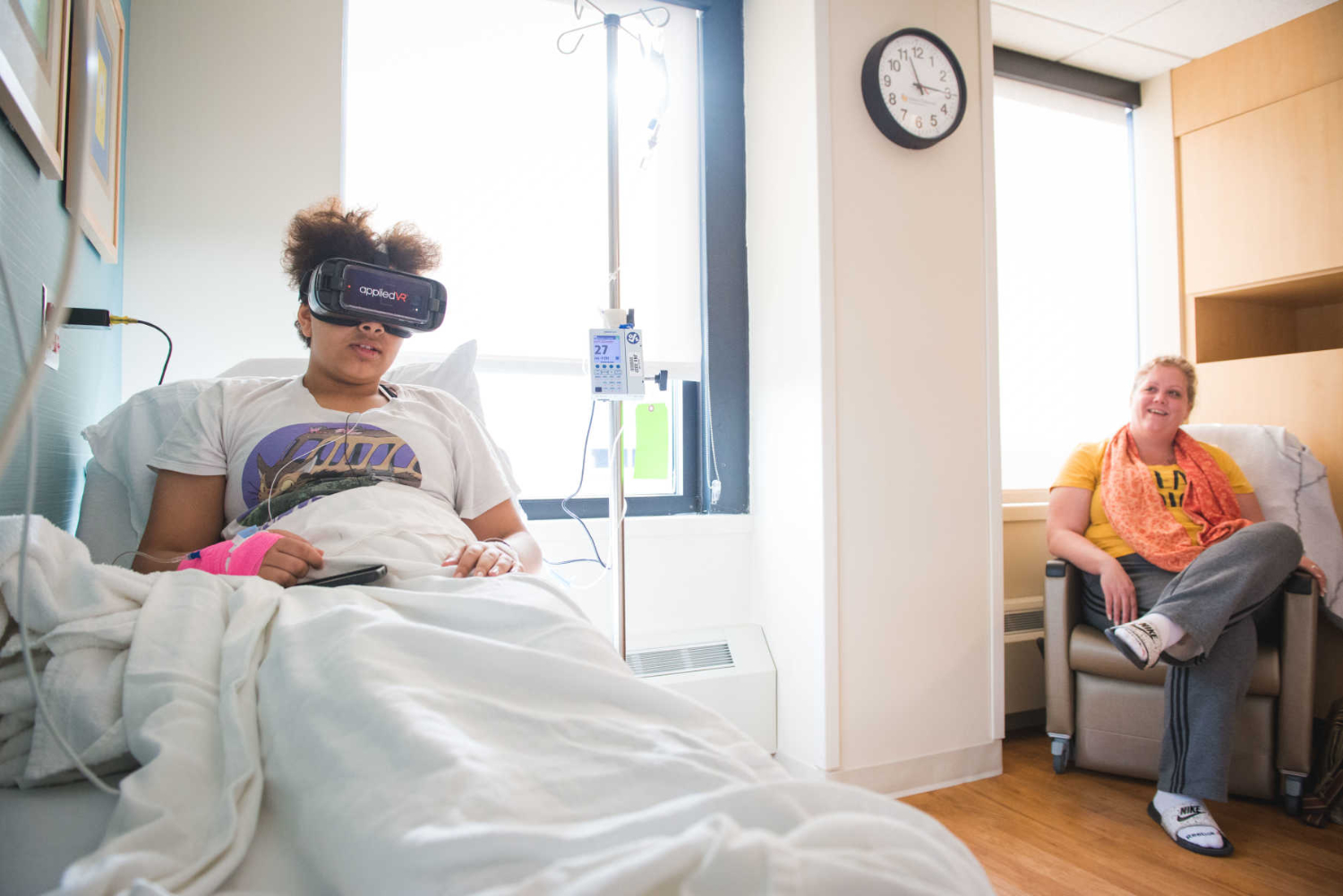 Olivia uses VR during her transfusion while her mother looks on