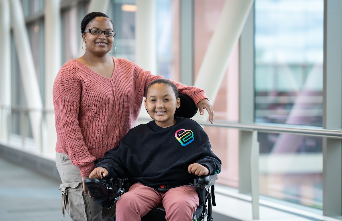 A young Gillette patient in a wheelchair and her mother