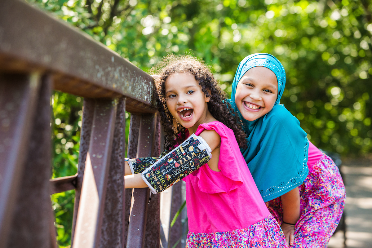 Gillette Children's patient, Amatullah, has Rett and is playing at the park with her family member.