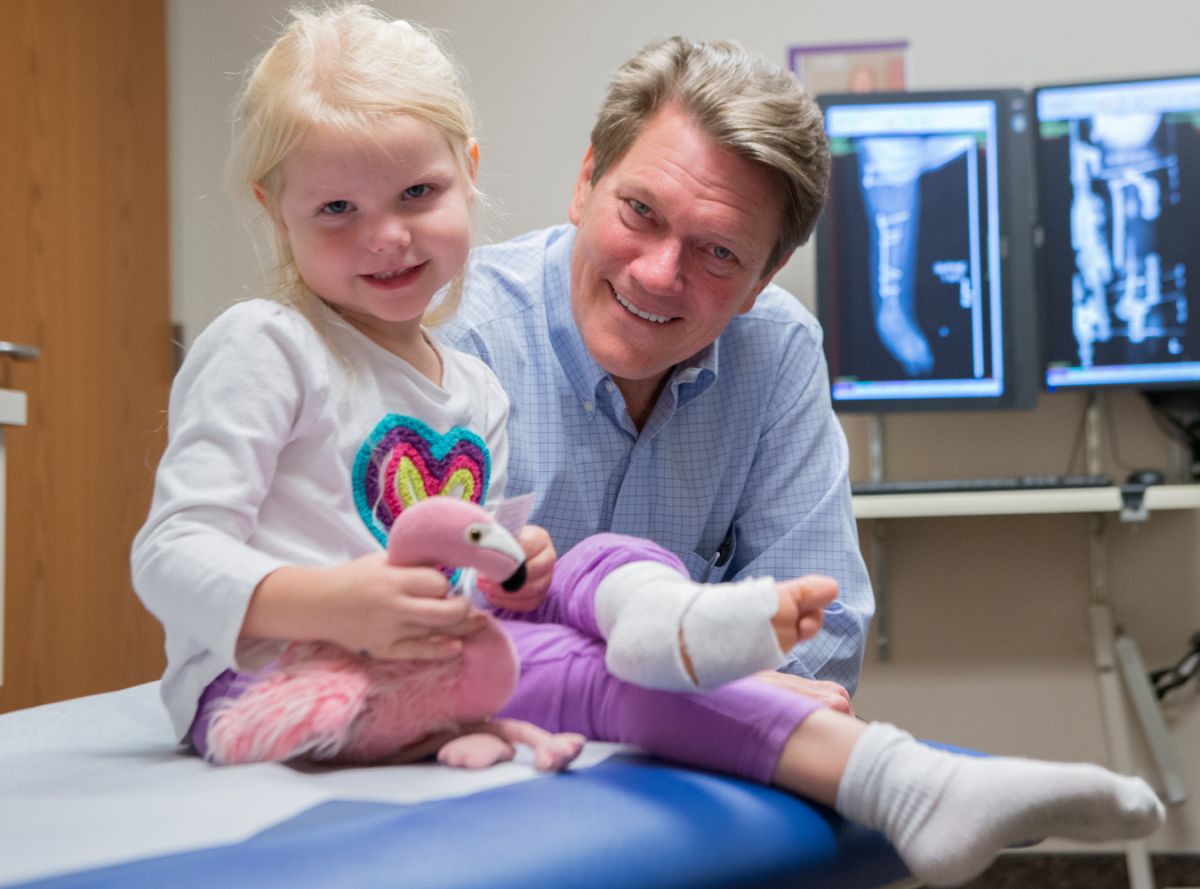 Mark Dahl, MD, poses with a happy patient at Gillette Children's.