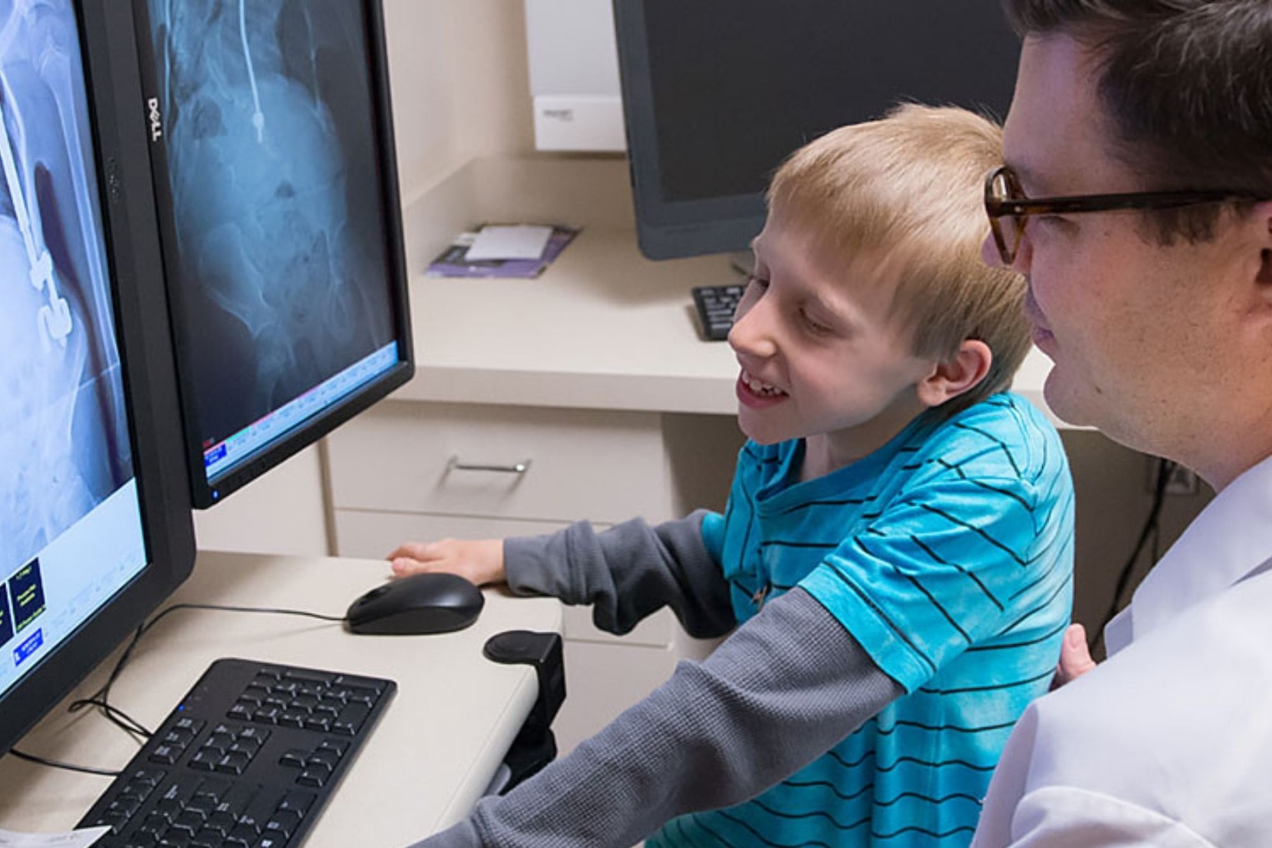 Gillette Children's patient looks at a spine x-ray with doctor.