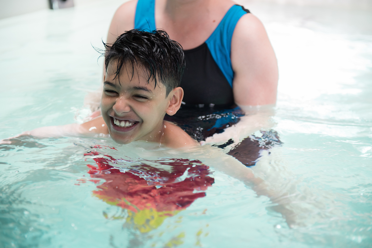 Patient Masood shown with care provider during aquatic therapy at Gillette Children's