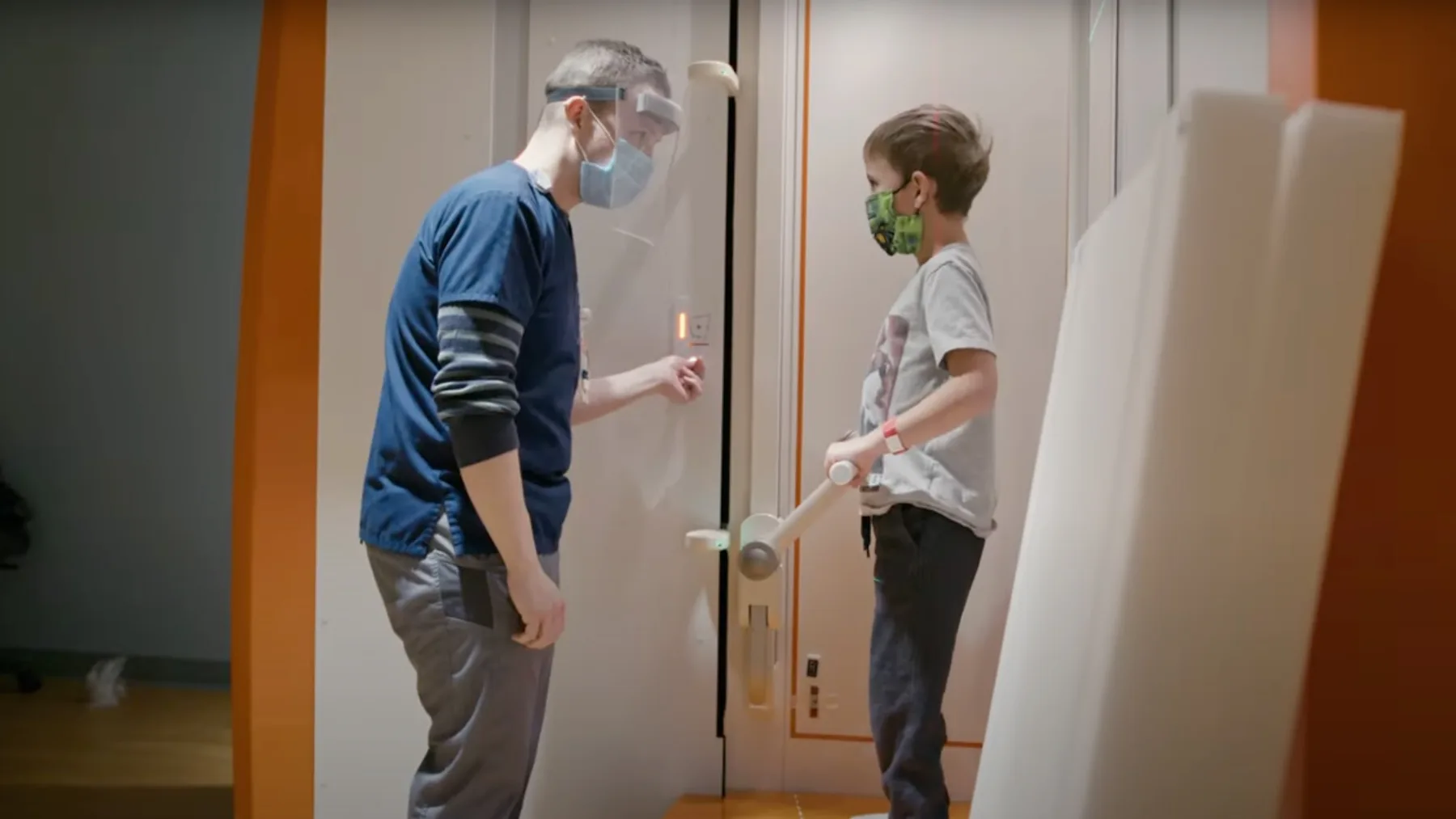 Two people facing each other wearing masks - Gillette Children's.