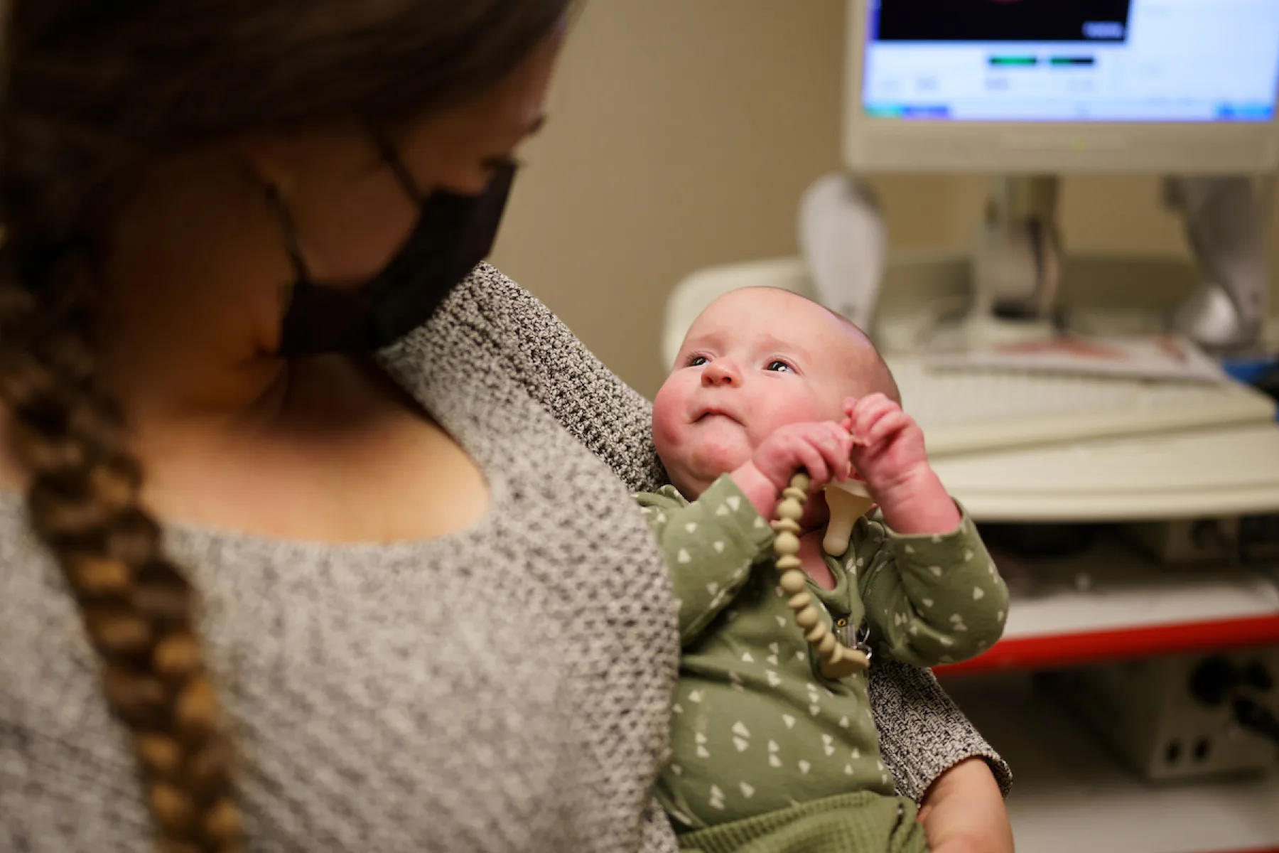 Little baby looking up at the woman holding it  - Gillette Children's.