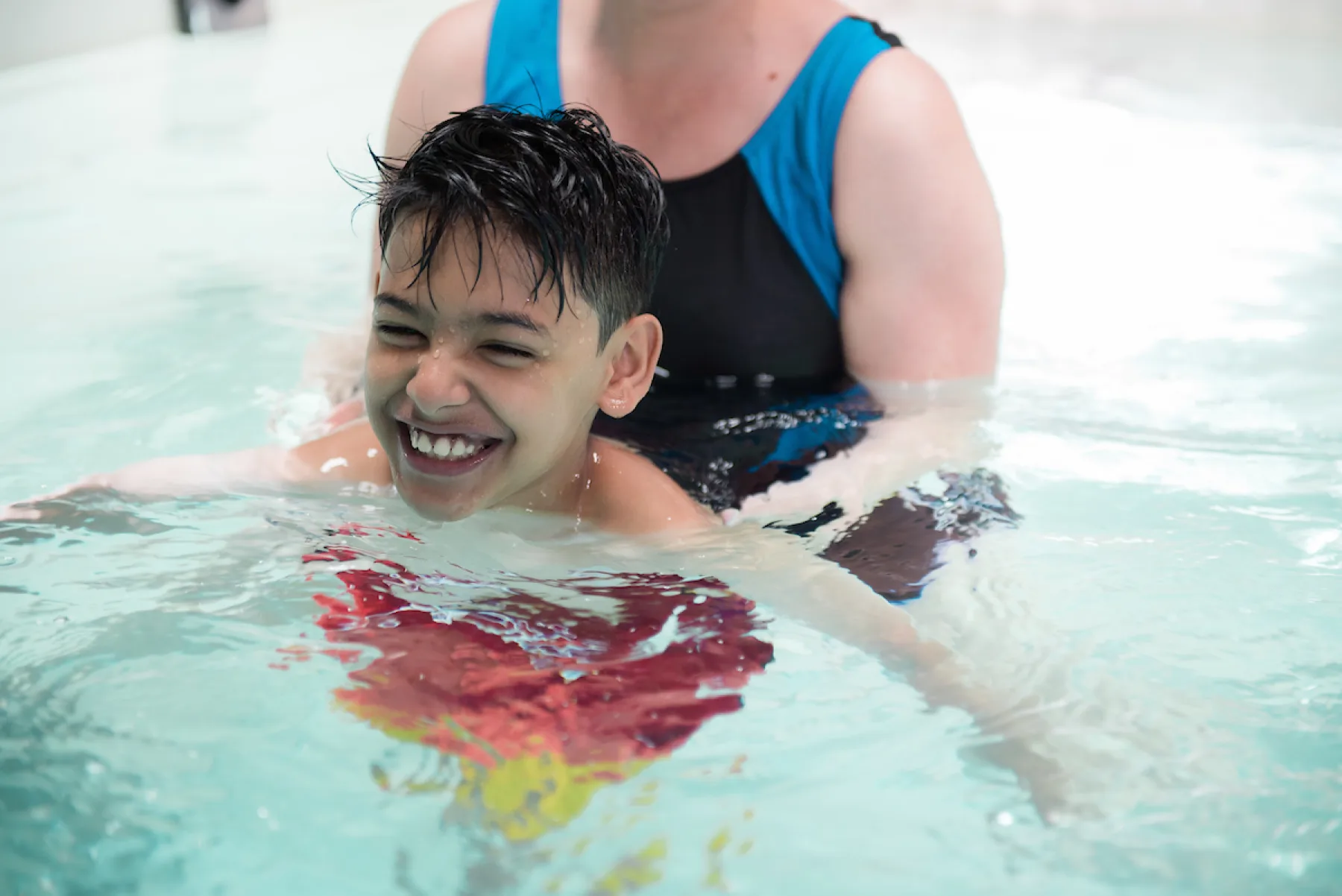 Patient Masood shown with care provider during aquatic therapy at Gillette Children's