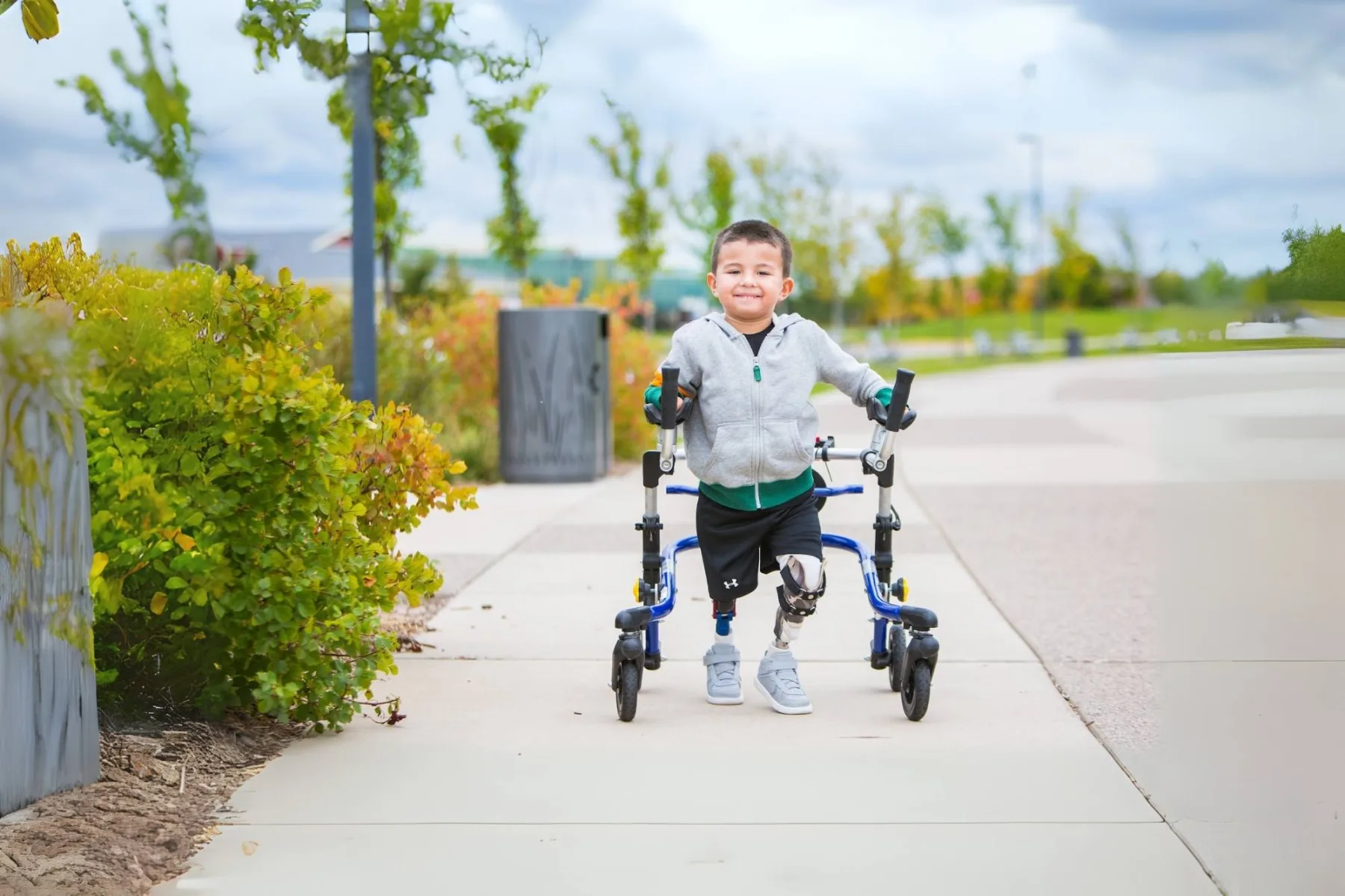 Boy with prosthetics and walker.