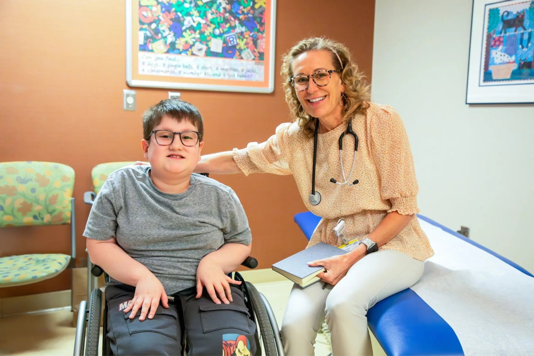 Patient sitting with provider in exam room  - Gillette Children's.