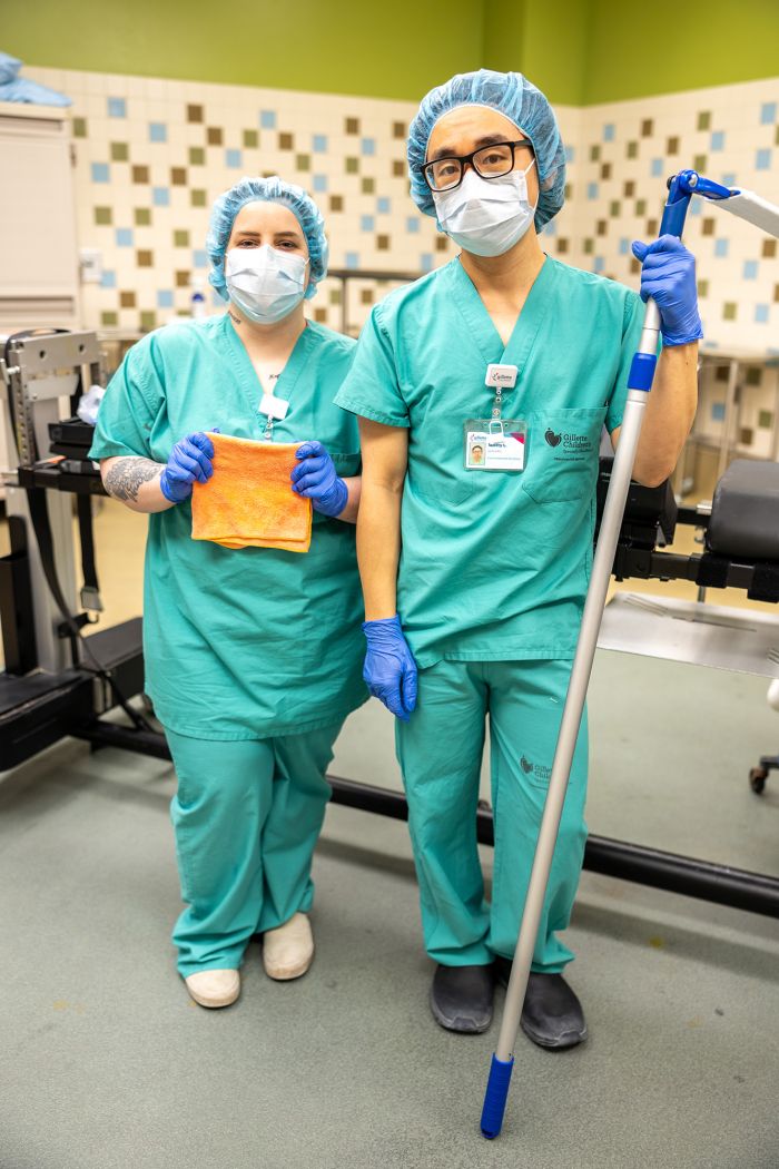 Gillette EOC staff Alysha Holmes and Scotty Lee pose in the operating room with cleaning supplies.