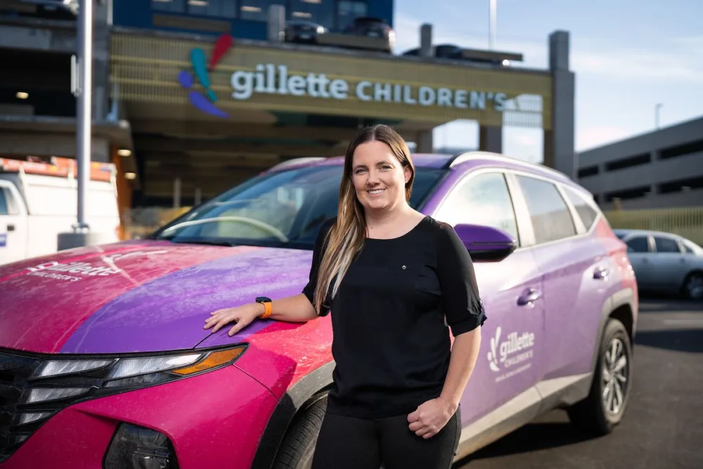 Dr. Andrea Paulson stands in front of Gillette Branded Car at Gillette Children's.