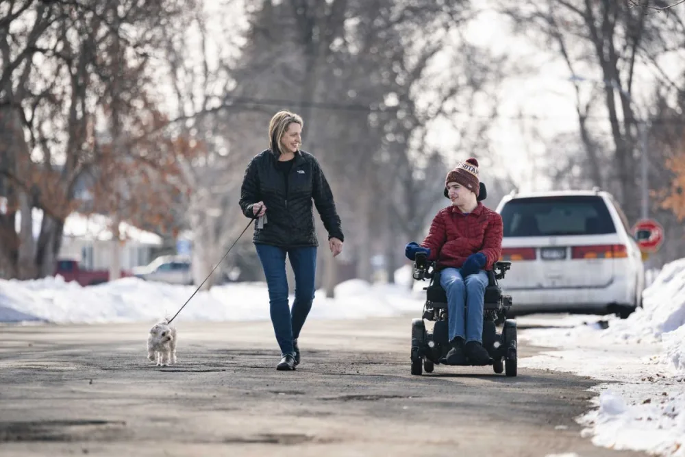 Joe and his mother, Kristi, take their dog Lucy for a walk with Gillette Children's.