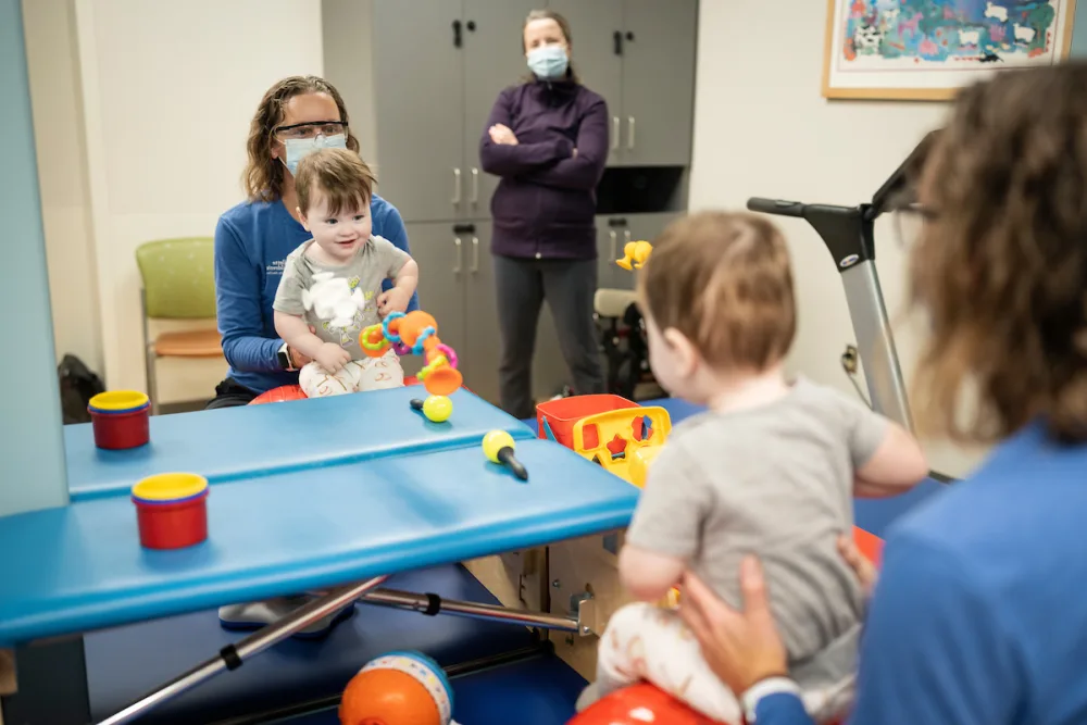 Provider and patient work through physical therapy in front of mirror at Gillette Children's.
