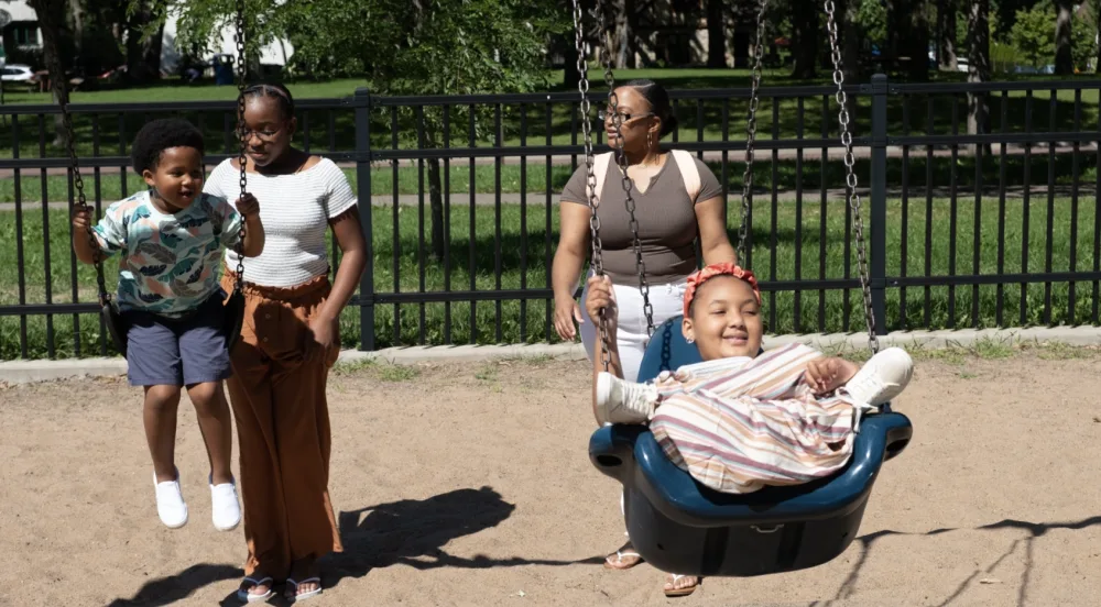 Photo of ZaNii on the swing at the park with Gillette Children's.