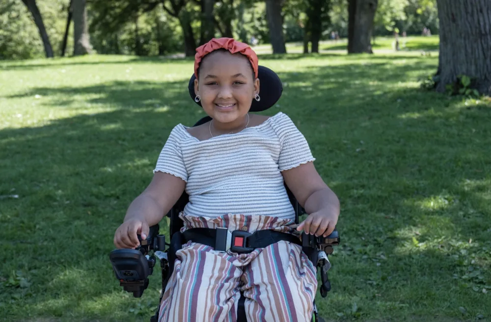 ZaNii smiles for a photo in the park with Gillette Children's.