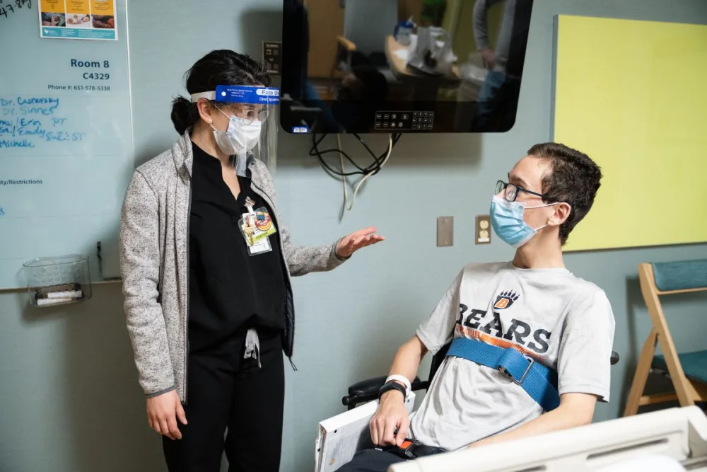 Caleb talks with provider at Gillette Children's.