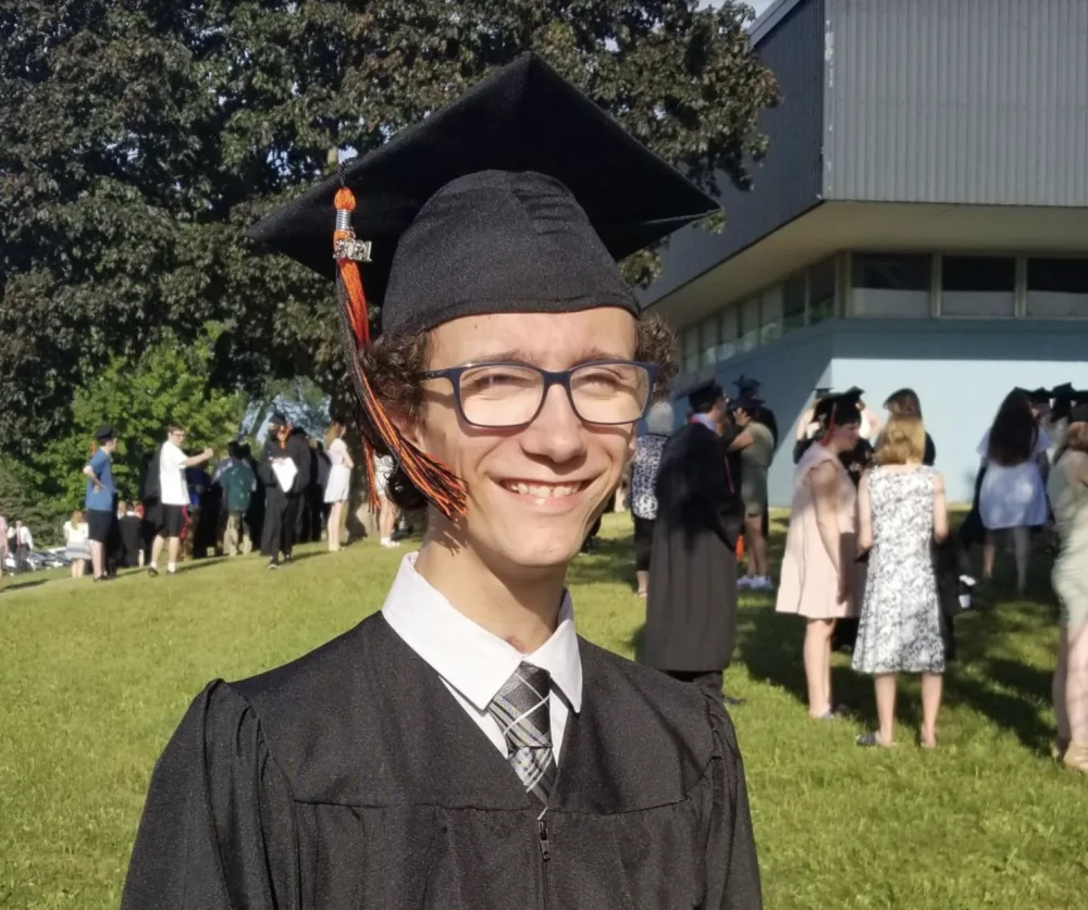 Caleb Binkert smiles at his high school graduation with Gillette Children's.