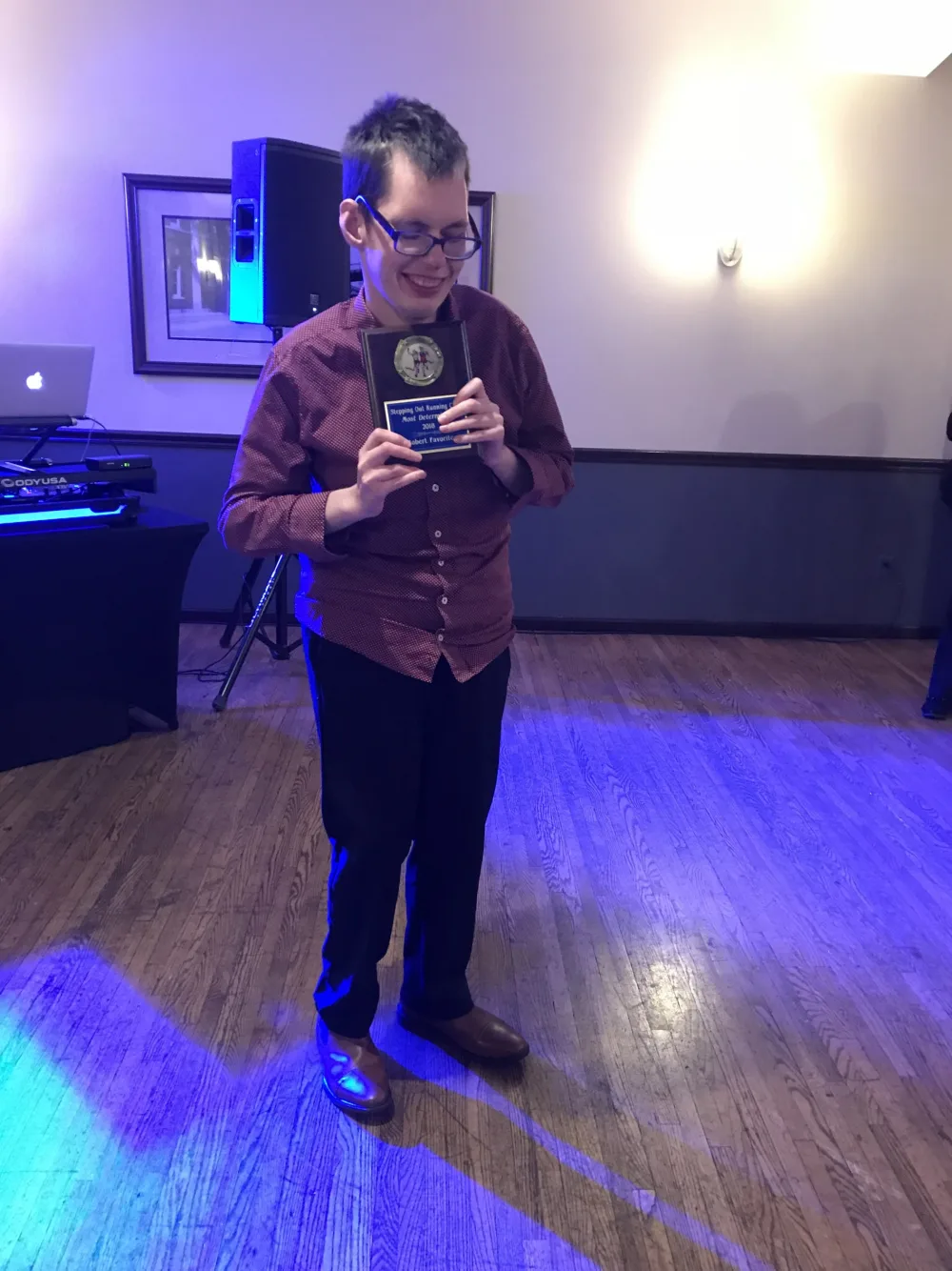 Robert smiling and holding award at Gillette Children's.