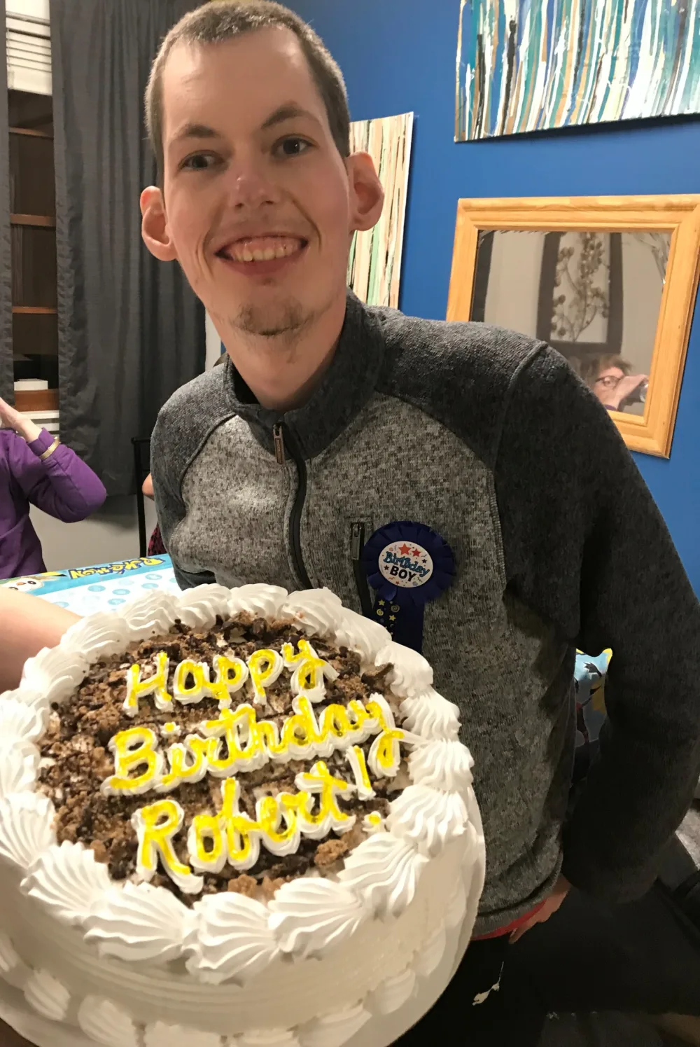 Robert smiling with birthday cake with Gillette Children's.