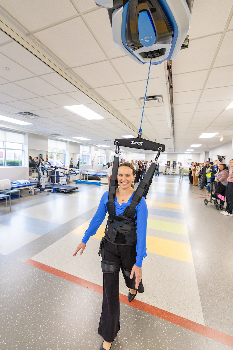 A Gillette Children's doctor demonstrating a new piece of harness equipment