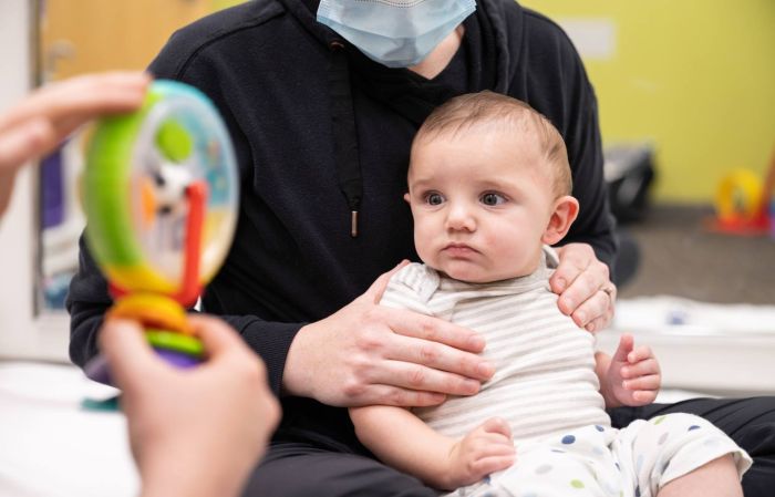 An infant with his head turned to the right to look at a colorful toy, Gillette Children's