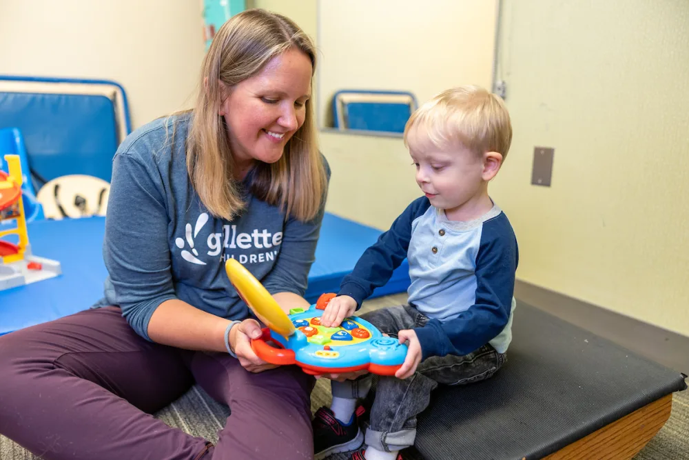 Gillette Children's physical therapist, Therese O'Bright works with a young boy in the rehab gym.
