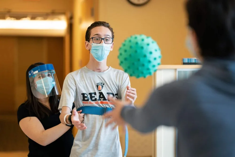 Gillette Children's patient Caleb Binkert practices physical therapy with Gillette provider.