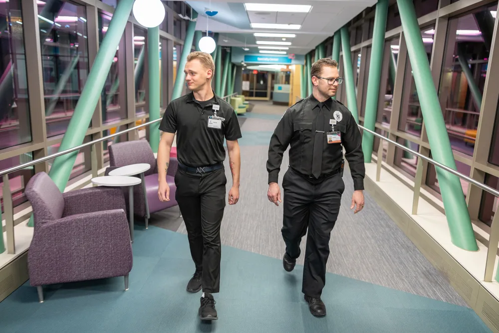 two security guards walking the hallway  - Gillette Children's.