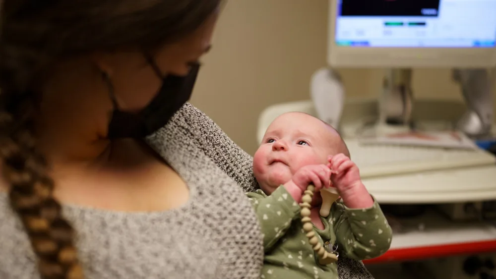 Baby being help by mother  - Gillette Children's.