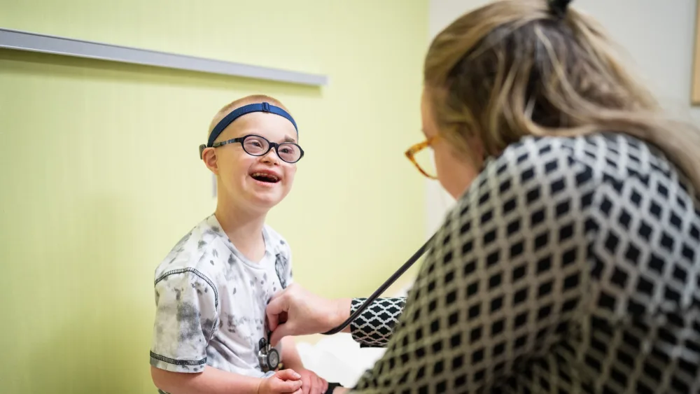 Gillette patient Peter Collins smiles as he is examined by Gillette provider Heidi Davis in the clinic.