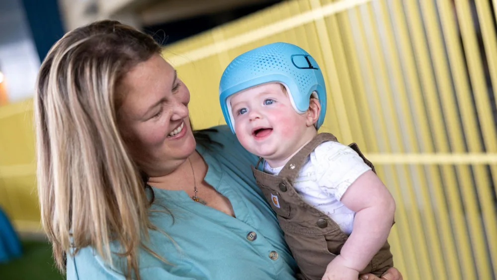 Mother with child wearing a Talee helmet.