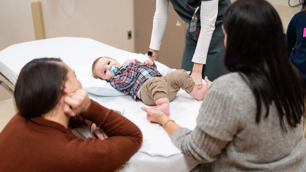 Wyatt Krentz is assessed in the Clubfoot Clinic as his mother looks on in January 2024.