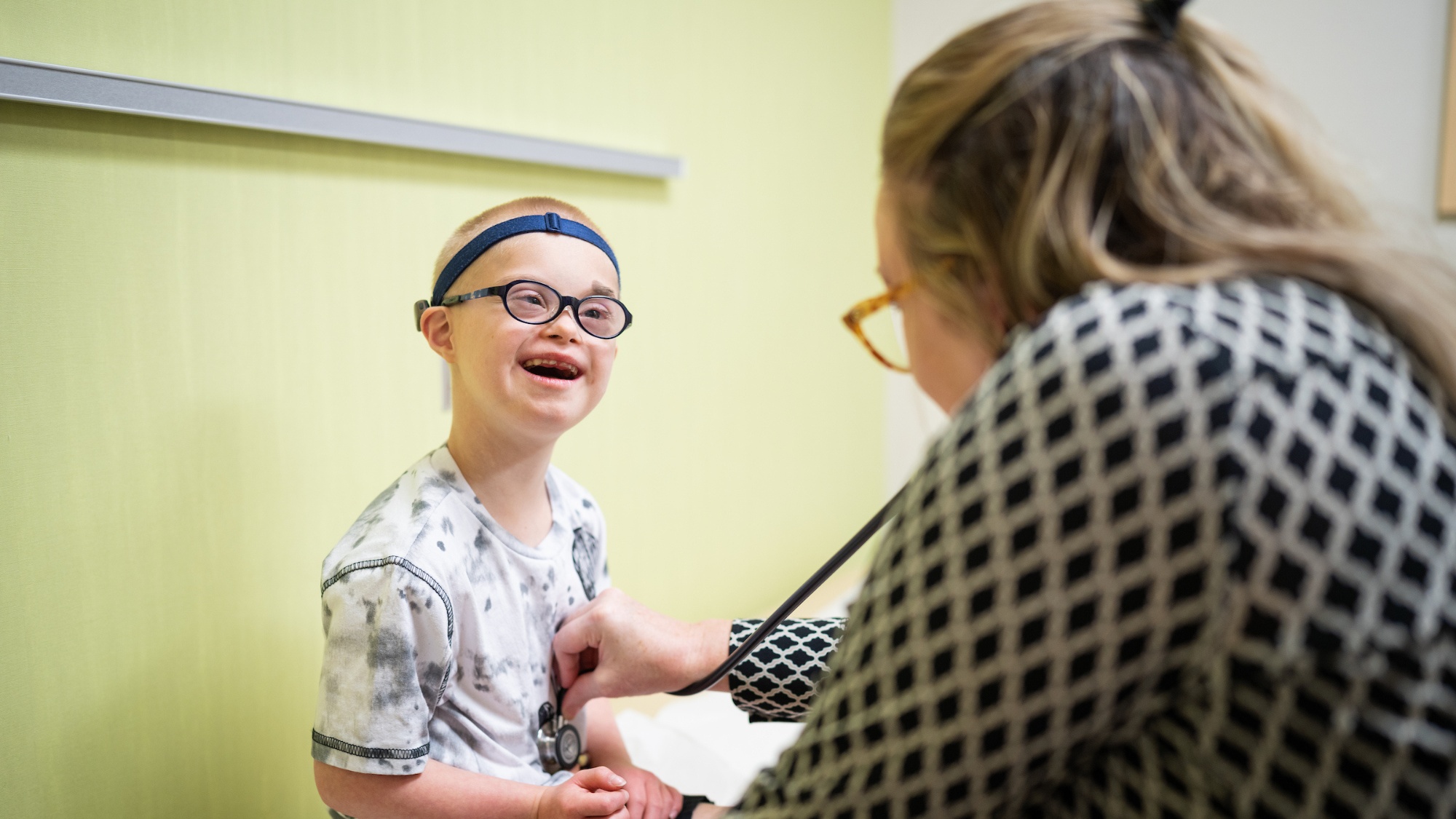 Gillette patient Peter Collins smiles as he is examined by Gillette provider Heidi Davis in the clinic.