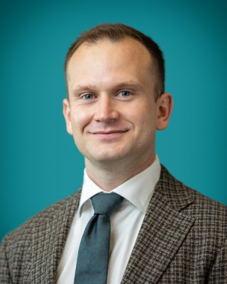 Portrait of Dr. Alexander Vasconcellos smiling.