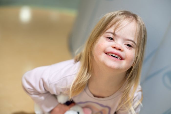 A young girls smiles in the lobby of Gillette Children's.