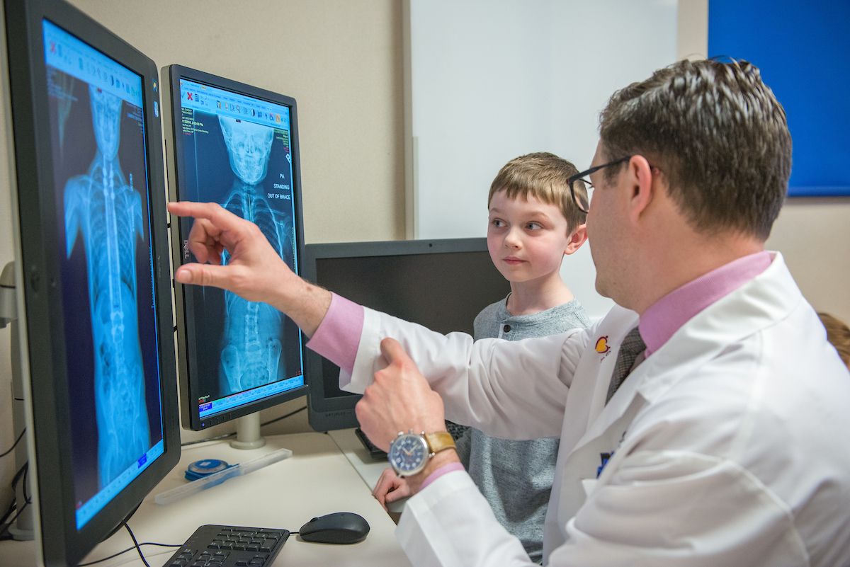Gillette orthopedic surgeon, Tenner Guillaume, shows Owen his spine x-ray images in 2018.