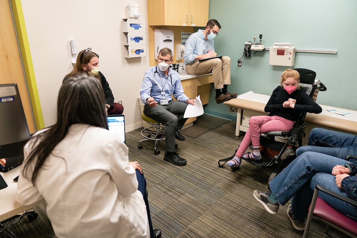Several Gillette providers are in an exam room to collaborate while treating a patient who has Rett syndrome.