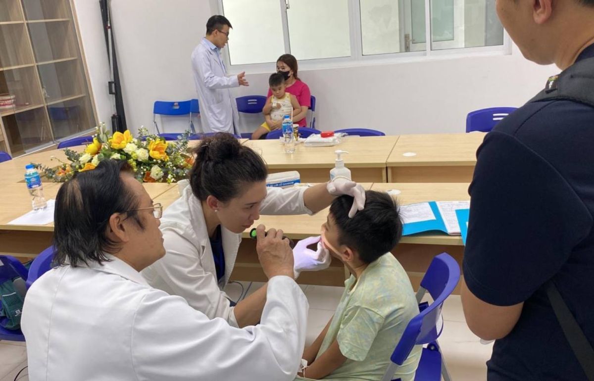 Gillette craniofacial and plastic surgeon, Jo Barta, MD, examines a patient in Vietnam.