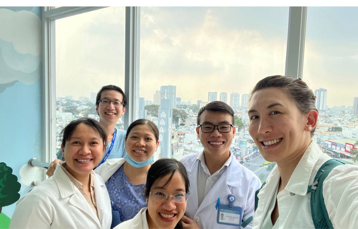 Dr. Barta with her colleagues in front of a large window in Vietnam.