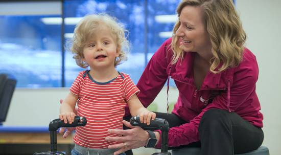 Lincoln with Kristine during physical therapy session at Gillette children's speciality healthcare minnetonka therapies location.