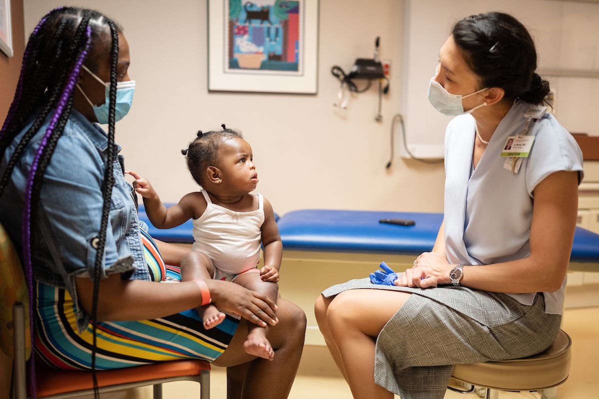 Delissa Kearney and her daughter Heavenly speak to Gillette pediatric plastic surgeon, Jo Barta, MD, during a post-surgical appointment for cleft lip repair. 
