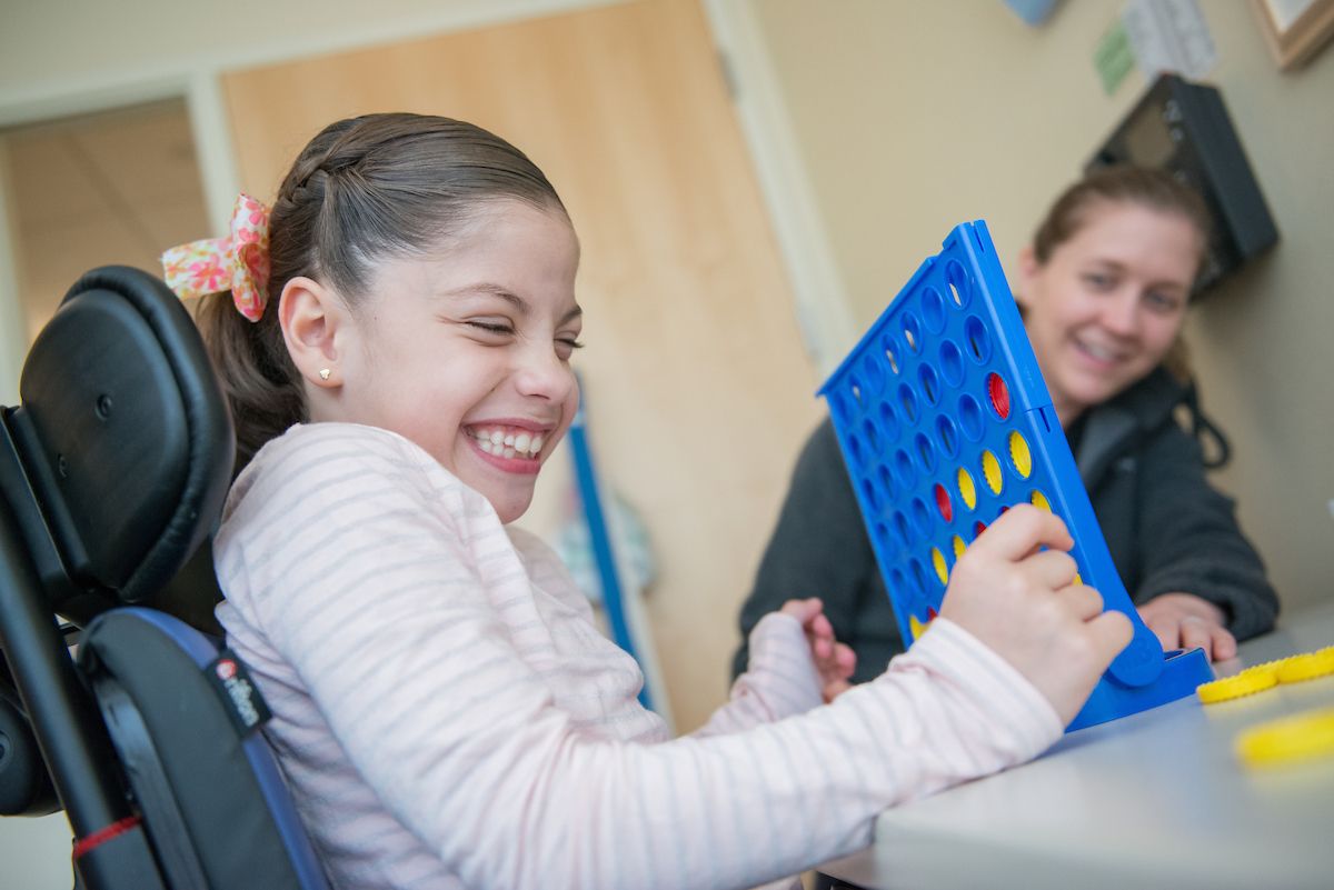 Maria Renata Sanchez plays Connect Four with a therapist. Gillette therapists are experts at making the hard work of rehabilitation seem fun. 