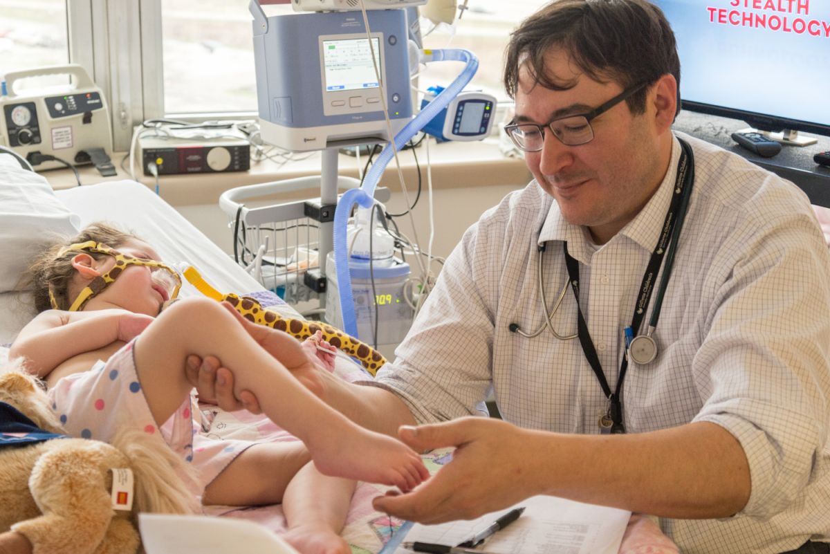 Randal Richardson, MD, examines the muscle tone of a SMA patient.